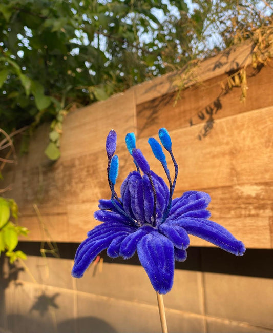 Blue artificial flower on a wooden background