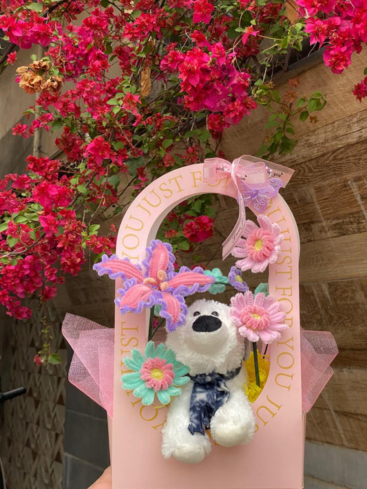 Decorative pink holder with a stuffed dog toy, flowers, and butterfly against a floral background.